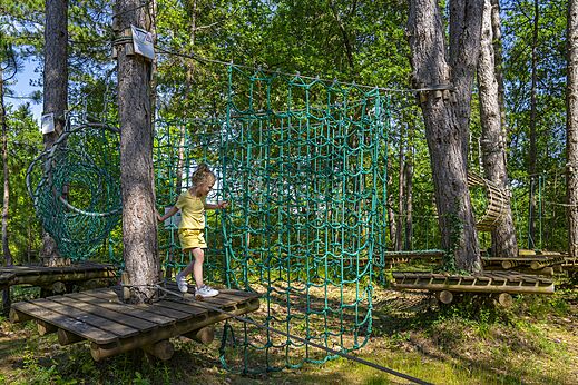 Ni�a en un circuito de aventura entre los �rboles del camping CLICOCHIC Lou Castel en Castelnaud-la-Chapelle (24).