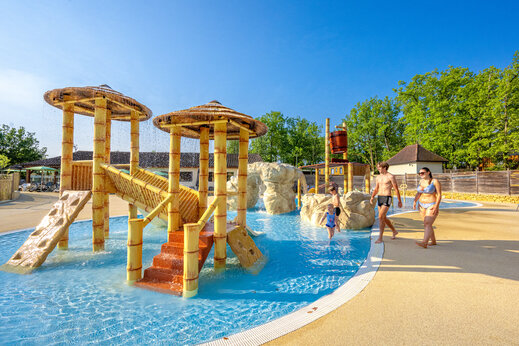 Zona de juegos acuáticos con toboganes y cubo basculante en el camping CLICOCHIC Lou Castel en Castelnaud-la-Chapelle (24).