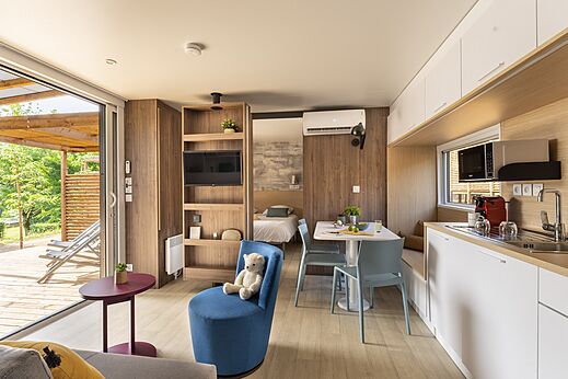 Interior moderno de Mobil-home con sala, cocina y terraza en el camping CLICOCHIC Lou Castel en Castelnaud-la-Chapelle (24).