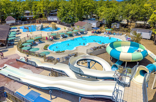 Zona acuática con piscinas, toboganes y juegos de agua en camping CLICOCHIC Lou Castel.
