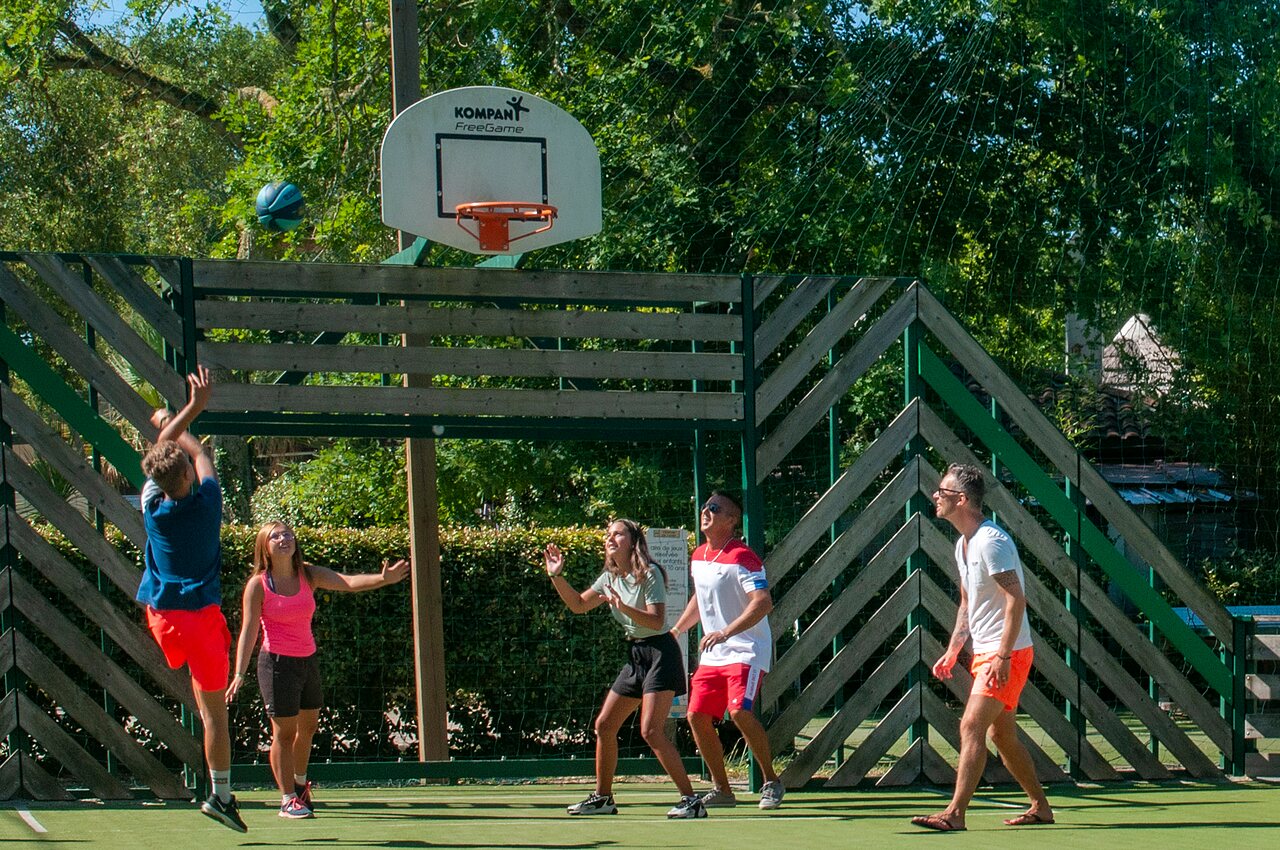 Familia jugando baloncesto en cancha multideportiva al camping CAPFUN Lou Puntaou en LEON (40).