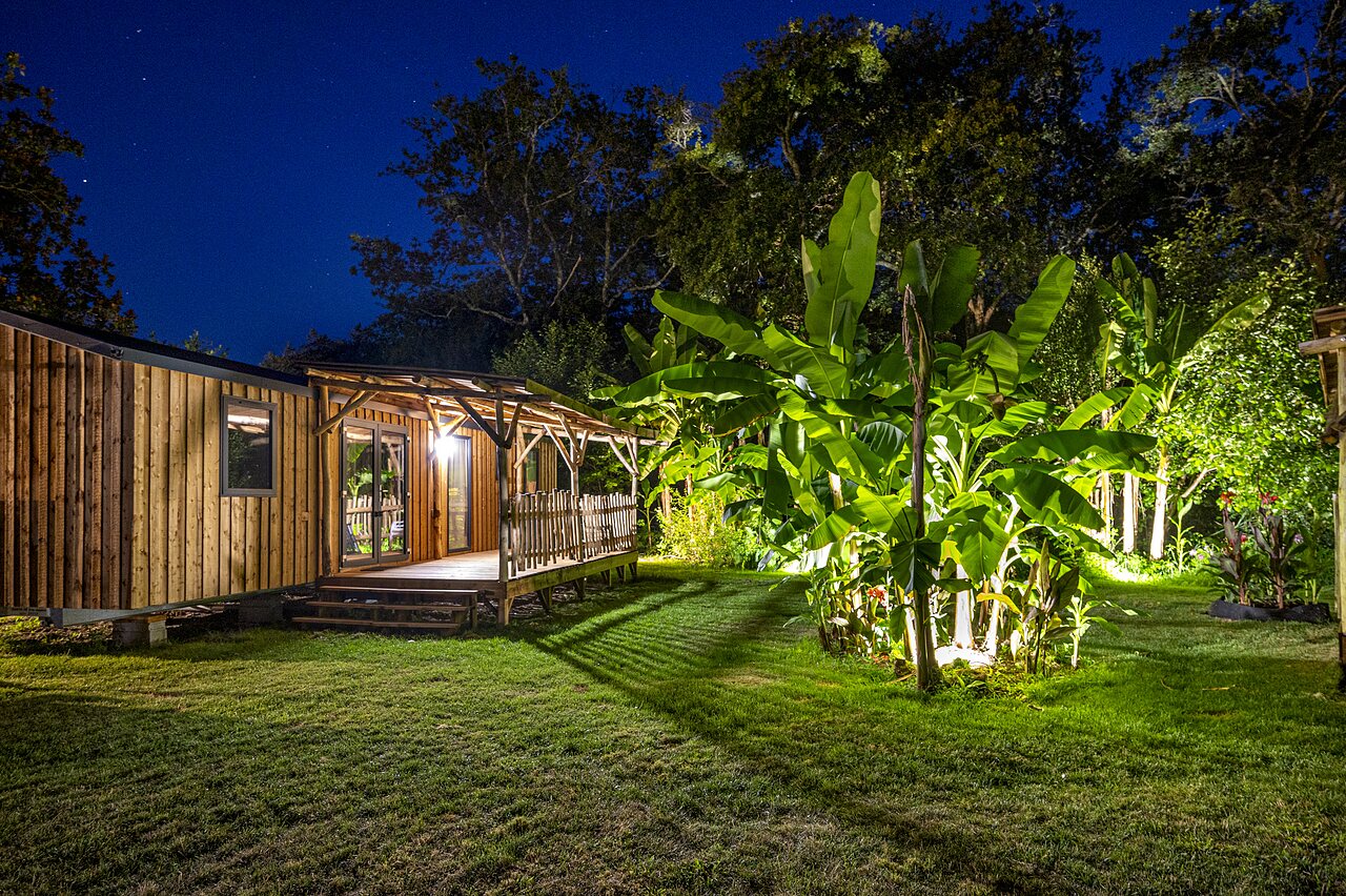 Mobil-home de madera, terraza iluminada, noche, en el camping CAPFUN Lou Puntaou en LEON (40).