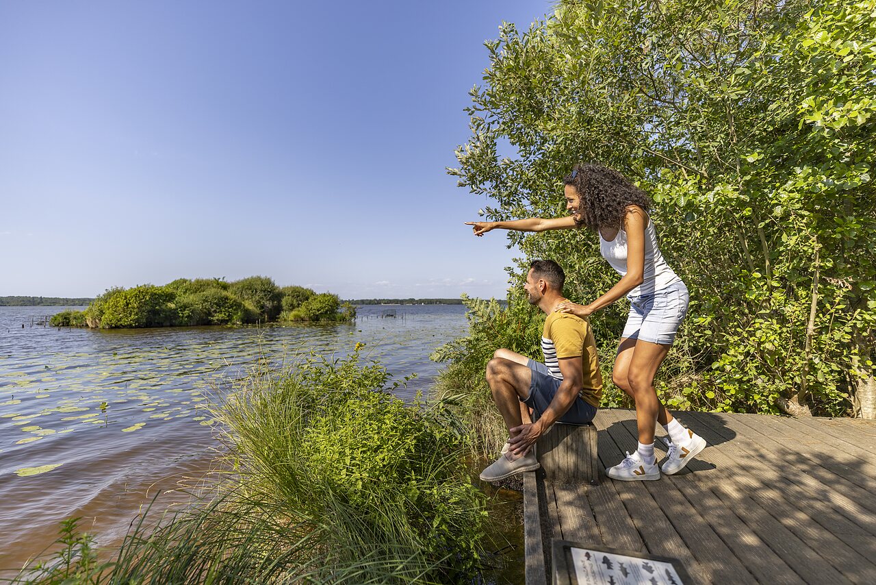 Pareja observando lago y naturaleza exuberante en el camping CAPFUN Lou Puntaou en LEON (40).