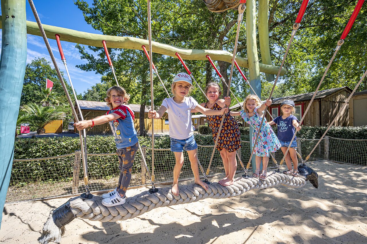 Ni�os sonrientes jugando en puente de cuerda en zona de juegos en camping CAPFUN Lou Puntaou en LEON (40).