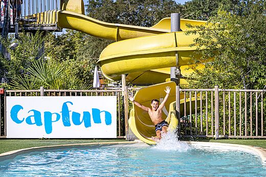Tobog�n acu�tico amarillo y ni�o en la piscina del camping CAPFUN Lou Puntaou en LEON.