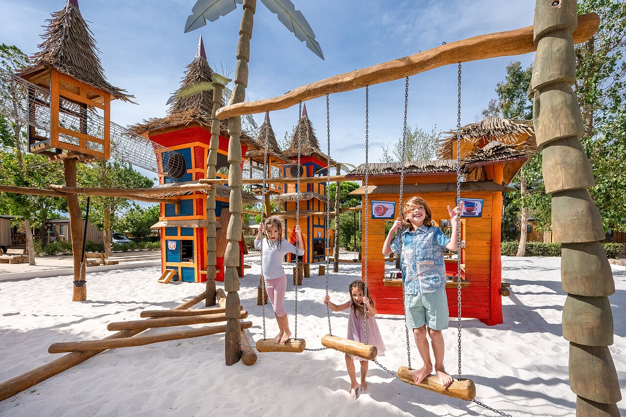 Zona de juegos, ni�os en columpios, camping CAPFUN Lou Village en Vendres (34).