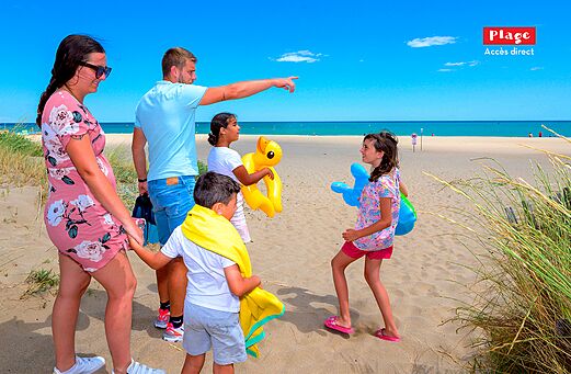 Familia en la playa de arena fina en el camping CAPFUN Lou Village en Vendres (34).
