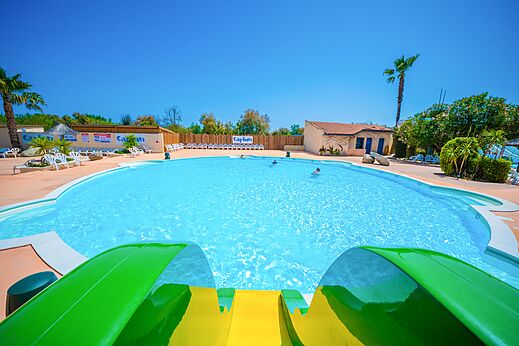Piscina exterior con tobogán acuático en el camping CAPFUN Lou Village en Vendres (34).