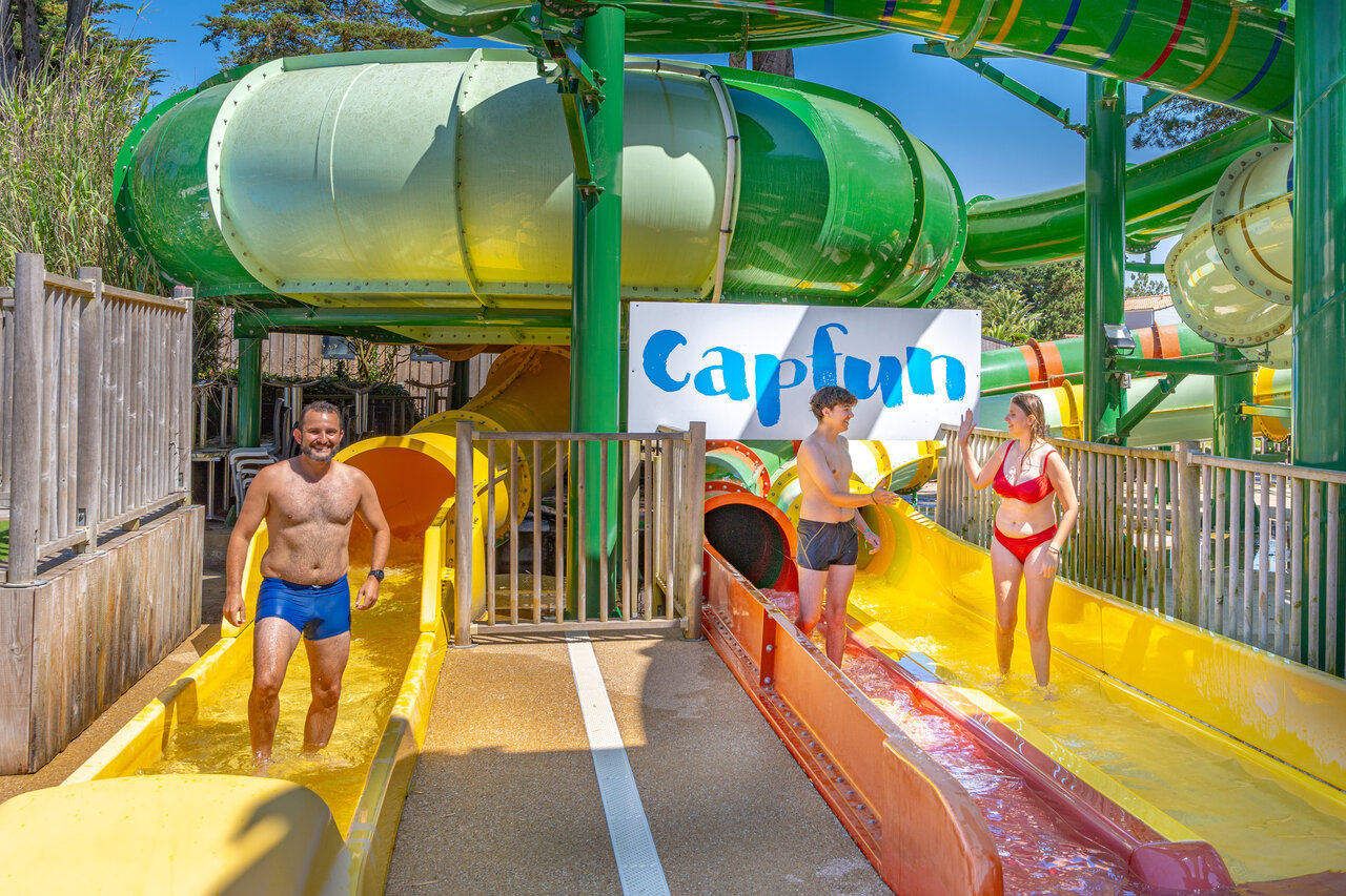 Toboganes acu�ticos coloridos y familia divirti�ndose en el camping CAPFUN Madrague en PORNIC (44).