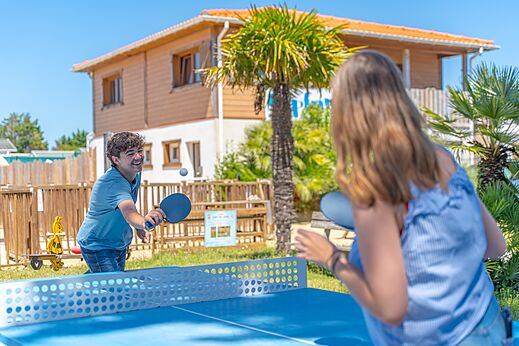 J�venes jugando al ping-pong en mesa azul en el camping CAPFUN Madrague en PORNIC (44).