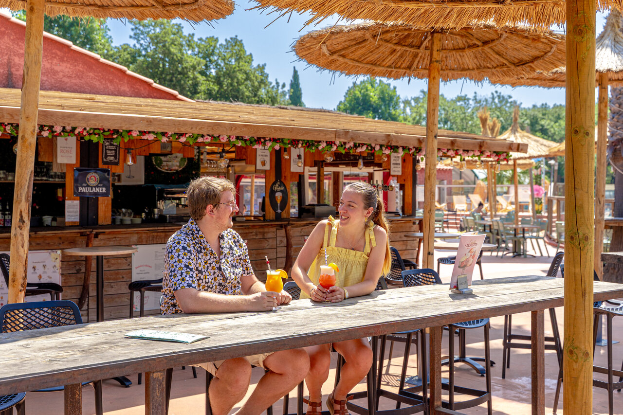 Pareja con c�cteles en el bar exterior, camping CAPFUN Mael en ARGELES SUR MER (66).