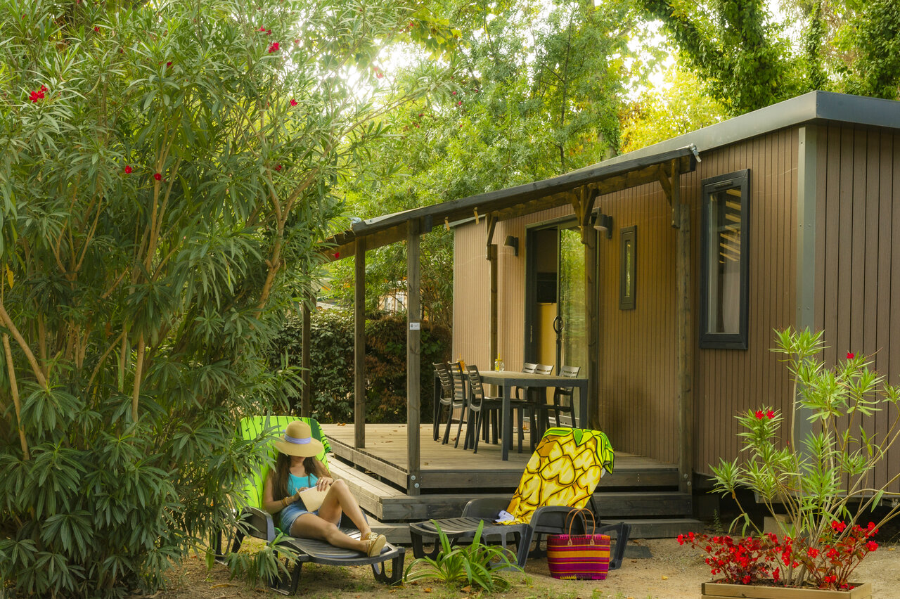 Mobil-home moderno con terraza y mujer relaj�ndose en camping CAPFUN Mael, ARGELES SUR MER (66).
