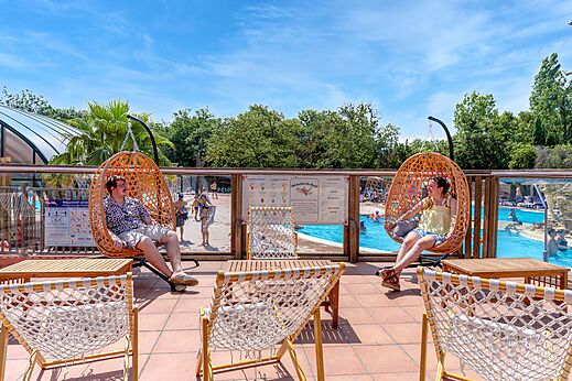 C�modas sillas colgantes y piscina exterior en el camping CAPFUN Mael en ARGELES SUR MER (66).