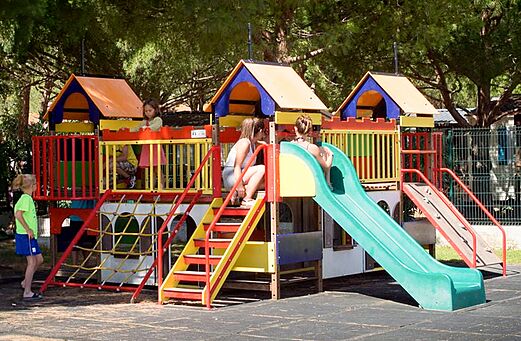 Zona de juegos colorida con toboganes y niños en el camping VAGUES OCEANES Manoir de Balkos en Valras-Plage (34).