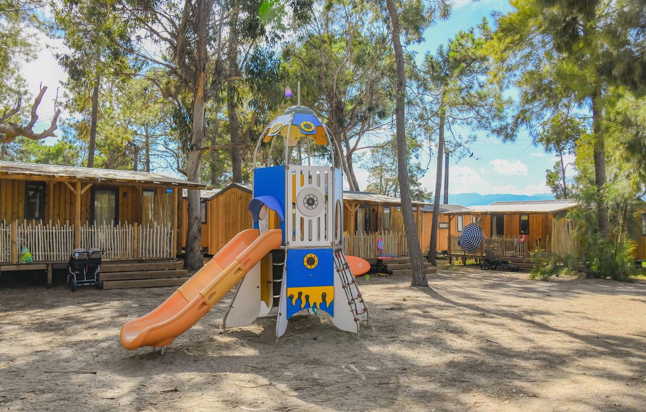Zona de juegos infantil con tobog�n y Mobil-homes en el camping CAPFUN Marina d'Al�ria en Aleria (20).