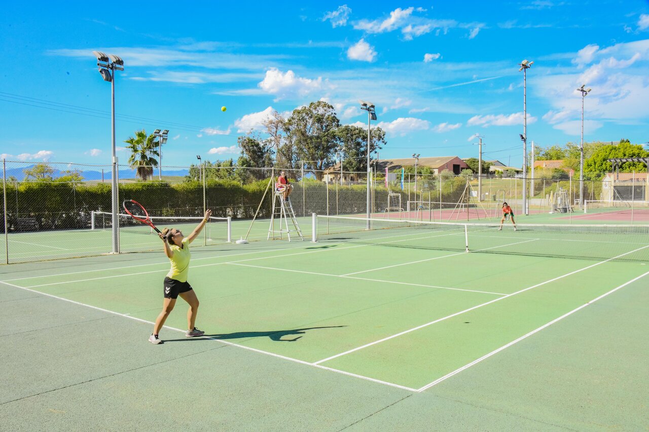 Cancha de tenis iluminada con jugadores en acci�n en el camping CAPFUN Marina d'Al�ria, Aleria (20).