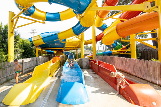 Toboganes acuáticos coloridos y niños divirtiéndose en el camping CAPFUN Marina d'Aléria en Aleria (20).