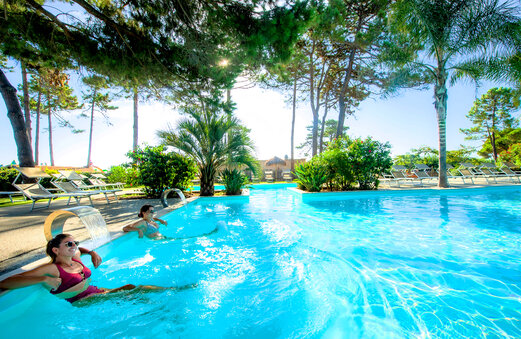 Piscina exterior con chorros de agua, mujeres en el camping CAPFUN Marina d'Aléria en Aleria (20).