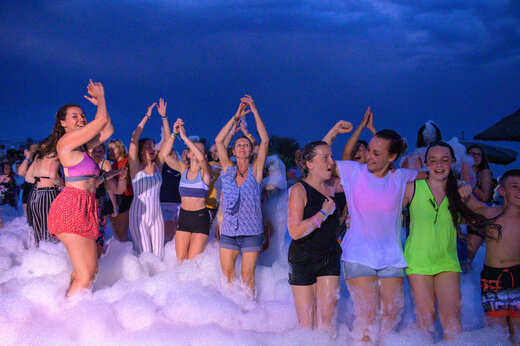 Fiesta de la espuma animada con campistas sonrientes en el camping CAPFUN Marina d'Aléria en Aleria (20).