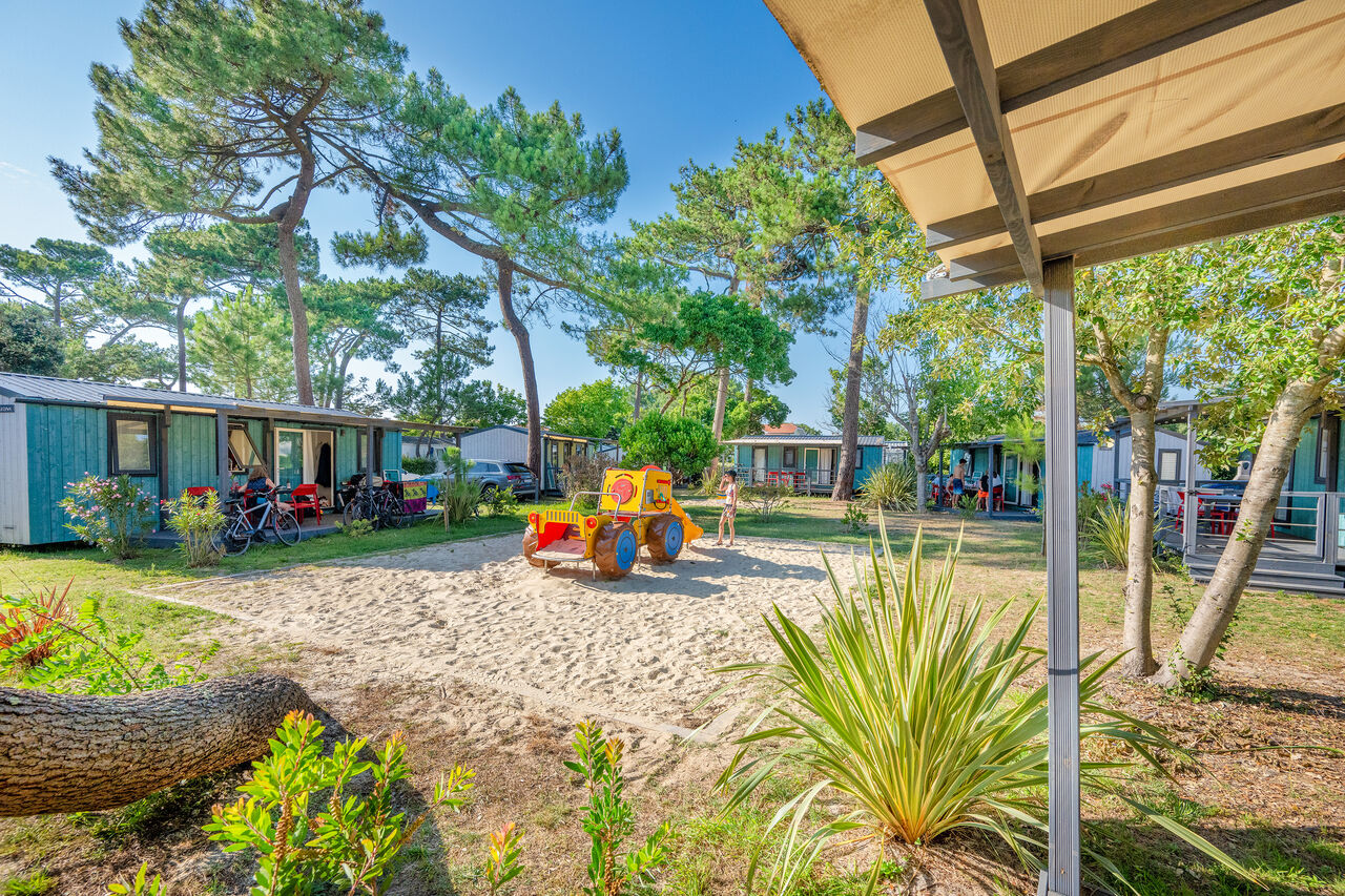 Mobil-homes, zona de juegos y pinos en el camping VAGUES OCEANES Marina Landes en Mimizan (40).