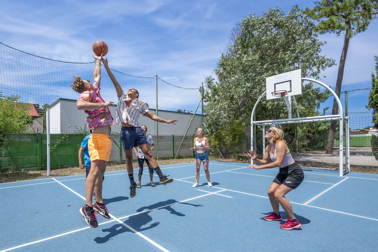 Jugadores de baloncesto en cancha multideporte en el camping VAGUES OCEANES Marina Landes en Mimizan (40).