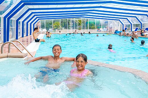 Piscina cubierta climatizada con ni�os sonrientes en el camping VAGUES OCEANES Marina Landes en Mimizan (40).