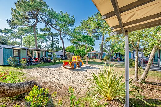 Mobil-homes y zona de juegos con tractor en el camping VAGUES OCEANES Marina Landes.