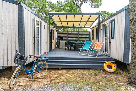 Mobil-home moderno, terraza y bicicleta en el camping VAGUES OCEANES Marina Landes en Mimizan (40).