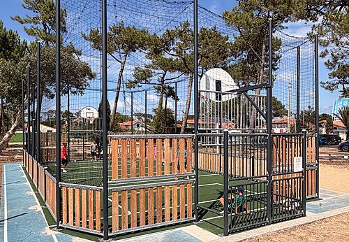 J�venes jugando baloncesto en una cancha multideporte en el camping VAGUES OCEANES Marina Landes en Mimizan (40).