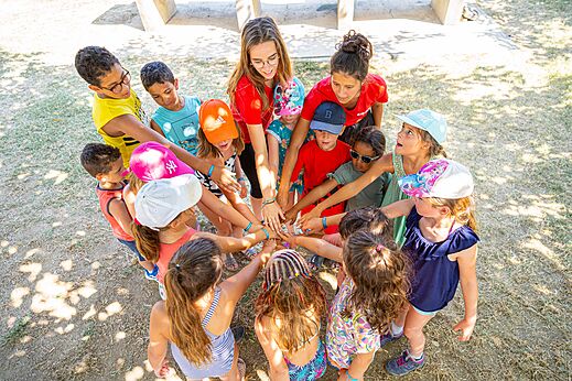 Ni�os y animadores en c�rculo, manos unidas para actividad grupal en el camping VAGUES OCEANES Marina Landes en Mimizan (40).