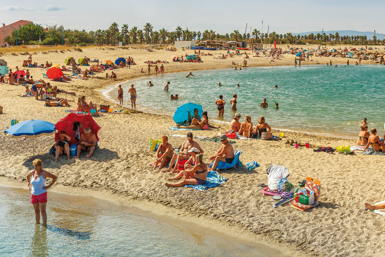 Playa de arena fina animada con ba�istas en el camping VAGUES OCEANES Marinette (66).