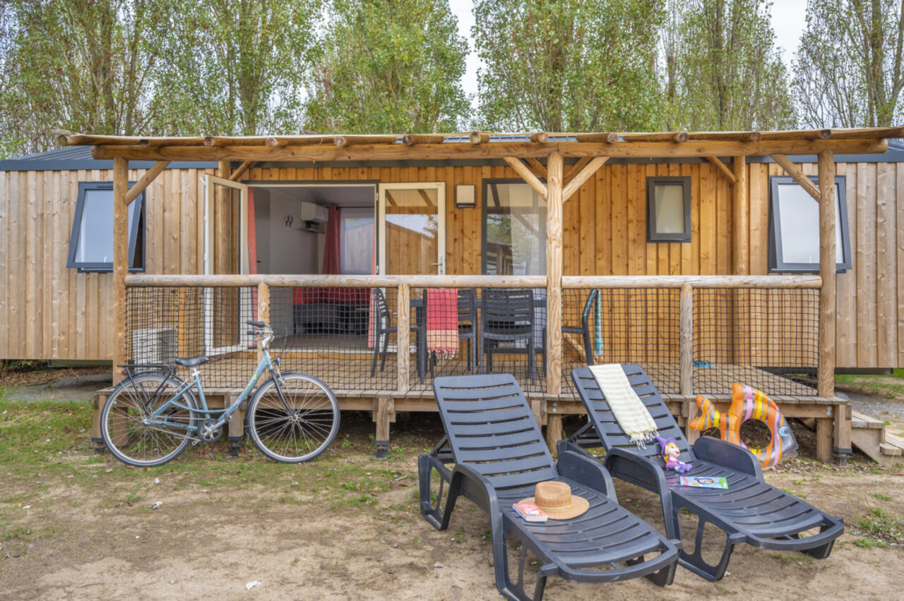 Mobil-home de madera, terraza amueblada, tumbonas, bicicleta en camping CLICOCHIC M�doc Bleu.