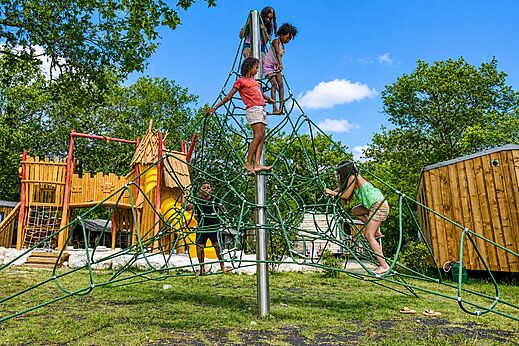 Niños en estructura de escalada de red en camping CLICOCHIC Médoc Bleu.