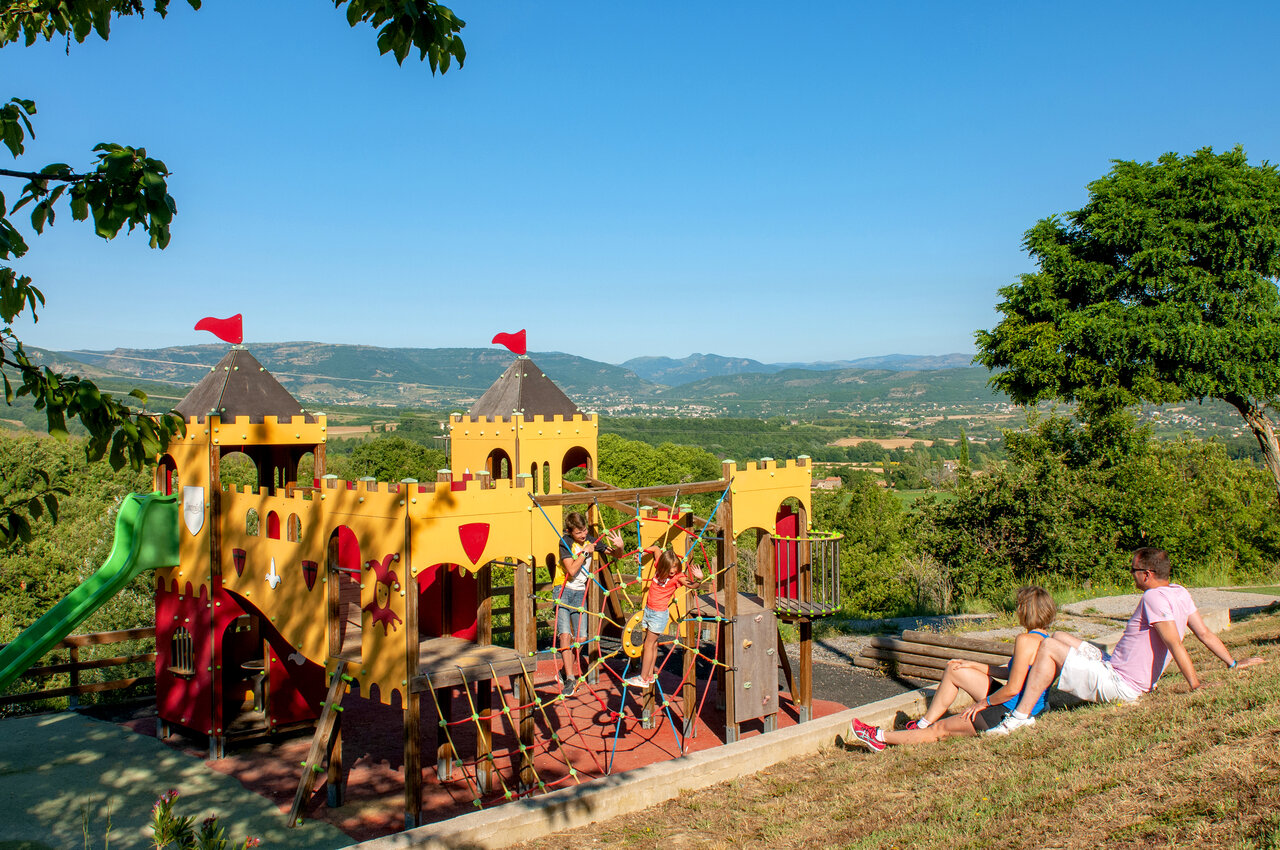 Parque infantil castillo con tobog�n y vista panor�mica en el camping CAPFUN Merle Roux en Baix (07).