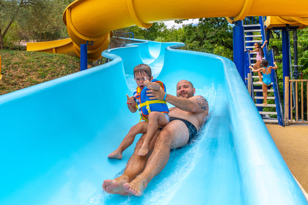 Padre e hijo en tobog�n acu�tico gigante en el camping CAPFUN Merle Roux en Baix (07).