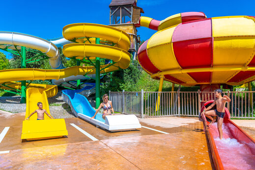 Toboganes acu�ticos gigantes y coloridos con ni�os en el camping CAPFUN Merle Roux (07).