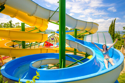 Joven mujer en tobog�n acu�tico azul, camping CAPFUN Merle Roux en Baix (07).
