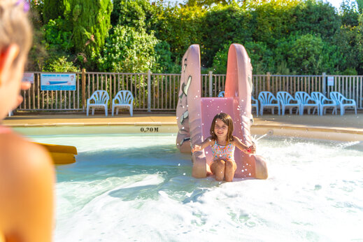 Ni�a en tobog�n acu�tico de piscina infantil en camping CAPFUN Merle Roux en Baix (07).