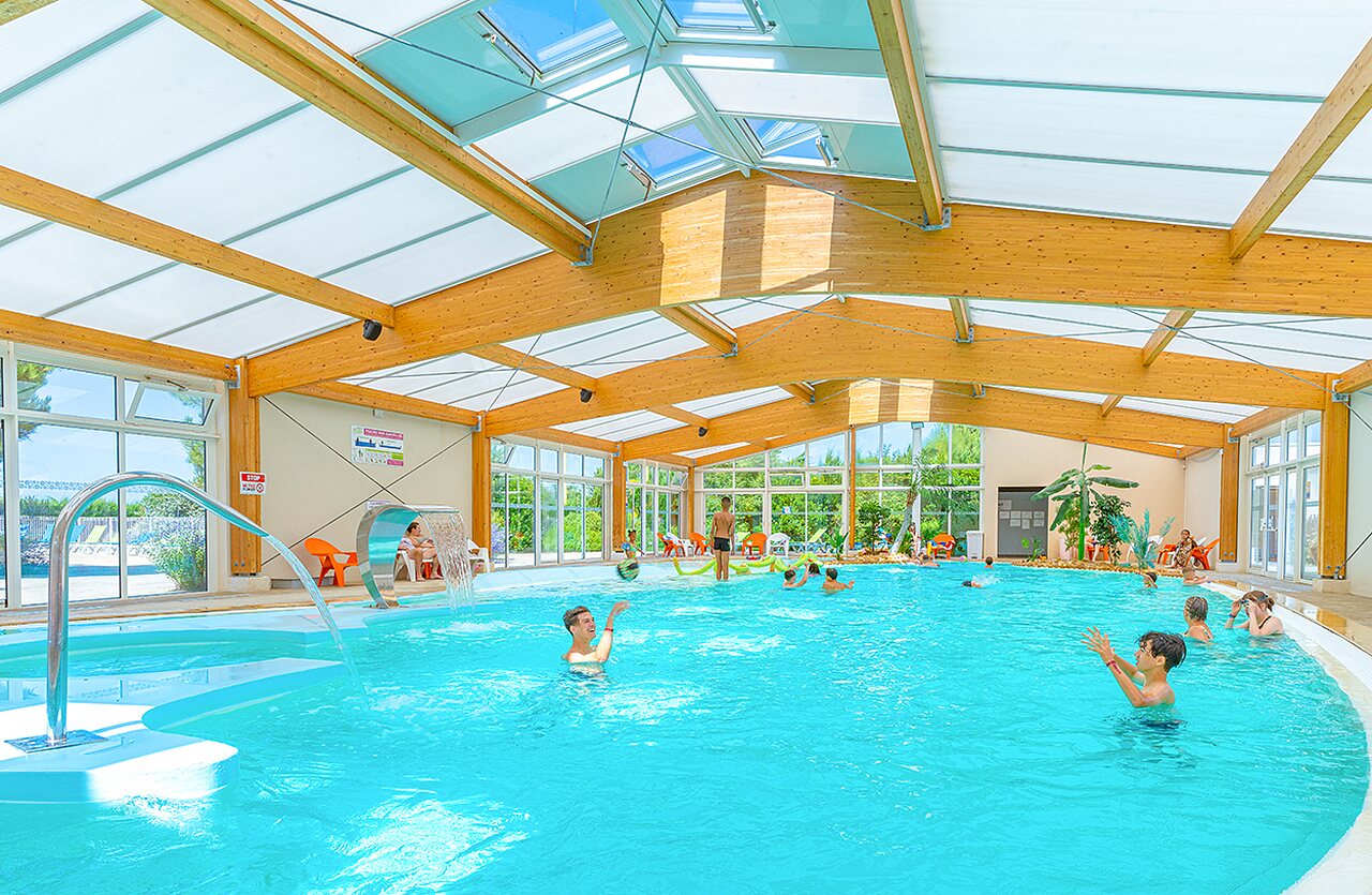 Piscina cubierta con juegos acu�ticos y ba�istas en el camping VAGUES OCEANES Micheli�re en Givrand (85).