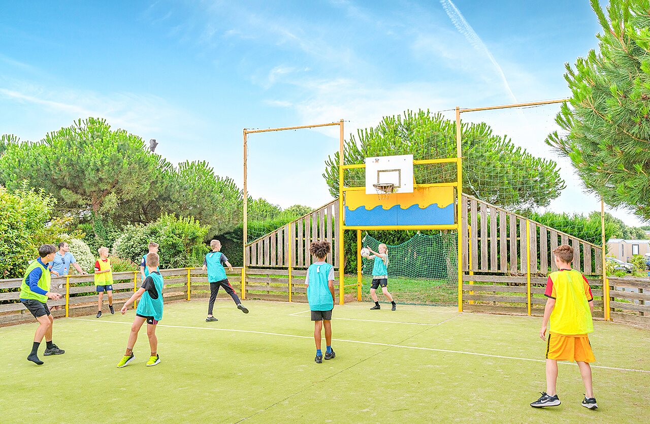 Ni�os jugando baloncesto en cancha multideportiva en camping VAGUES OCEANES en Givrand.