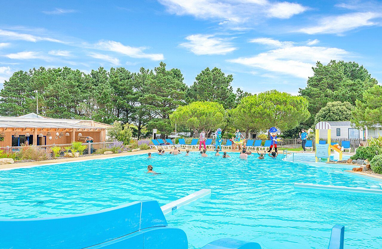 Piscina exterior animada con tobog�n y juegos acu�ticos en el camping VAGUES OCEANES Micheli�re en Givrand (85).