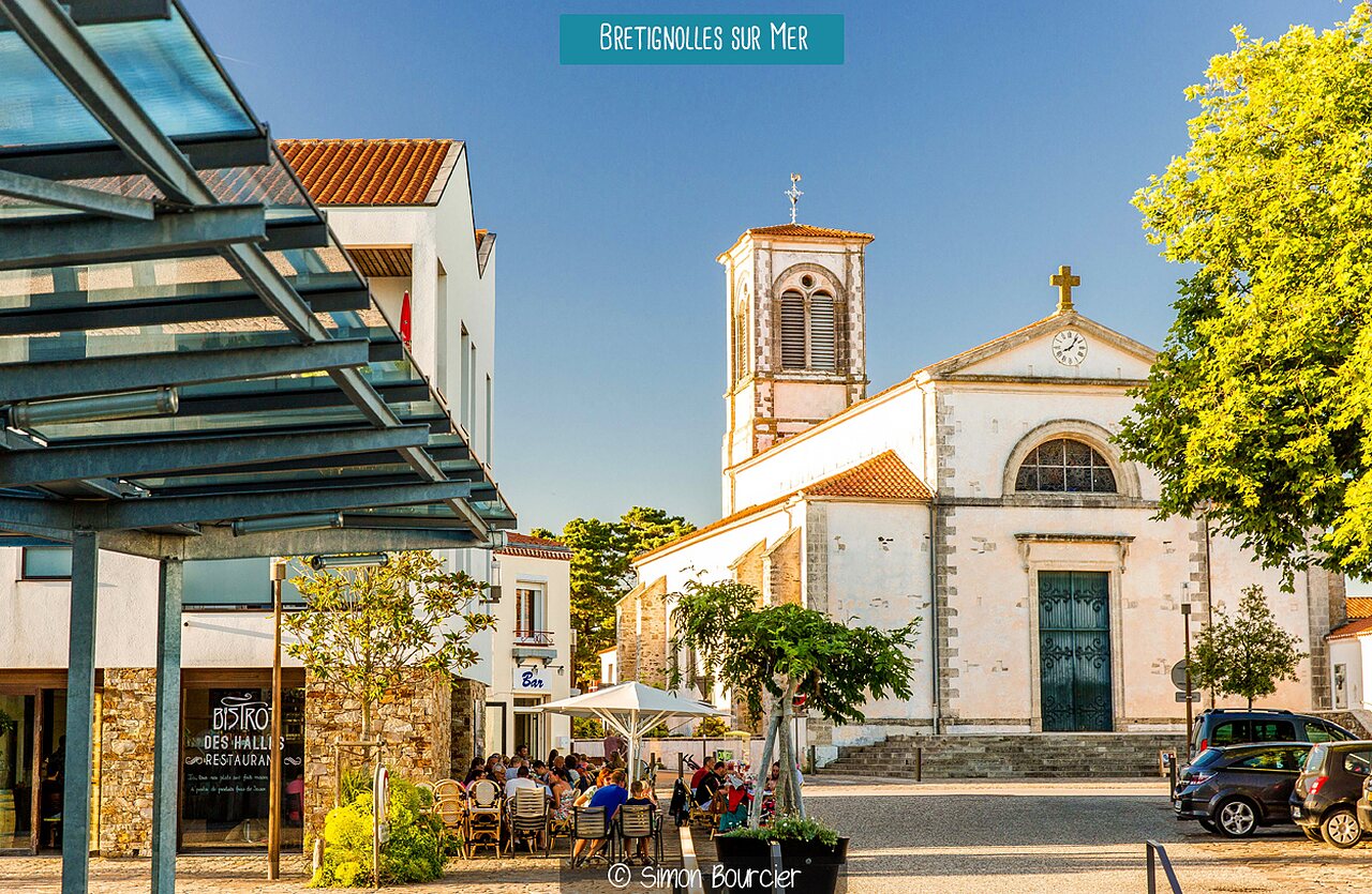 Plaza de la iglesia Saint-Nicolas con terrazas animadas en Br�tignolles-sur-Mer, Vandea.