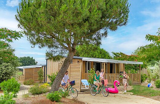 Mobil-homes modernos con terraza y bicicletas en camping VAGUES OCEANES Michelière, Givrand (85).