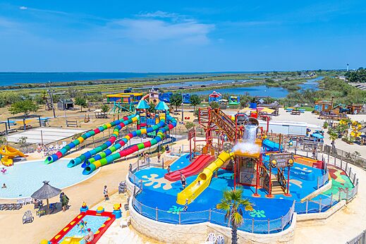Gran parque acuático con toboganes coloridos y piscina en el camping CAPFUN Mille Pépites en Carnon (34).