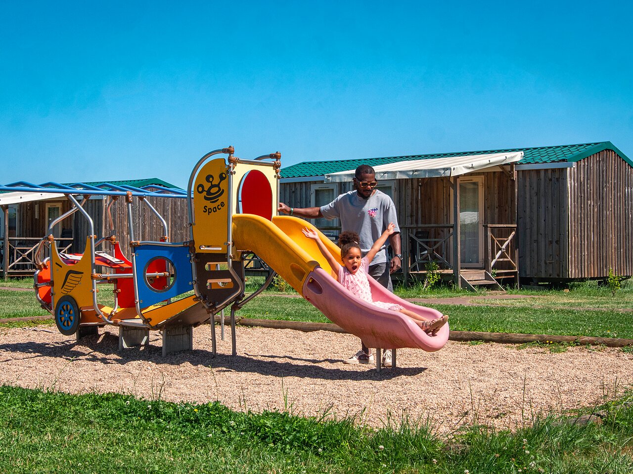 Ni�a en tobog�n, parque infantil, Mobil-homes en el camping CAPFUN Mirabelle en VOLSTROFF (57).