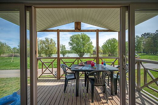 Terraza cubierta de Mobil-home con vistas al lago en el camping CAPFUN Mirabelle en VOLSTROFF (57).