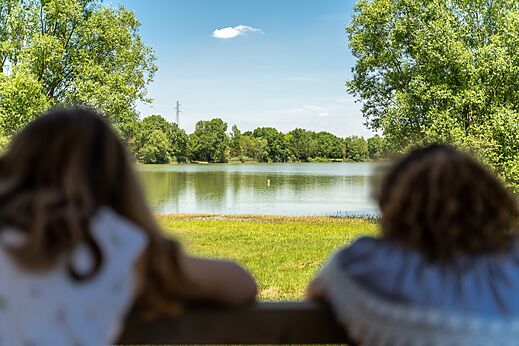 Lago tranquilo rodeado de �rboles verdes en el camping CAPFUN Mirabelle en VOLSTROFF (57).