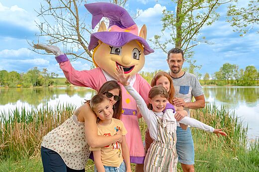 Mascota y familia sonriente junto al lago en el camping CAPFUN Mirabelle VOLSTROFF.