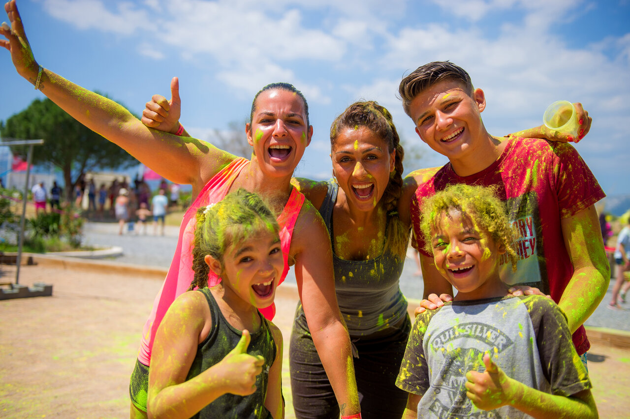 Familia sonriente con polvo de colores en animaci�n de camping CAPFUN Mirmanda.