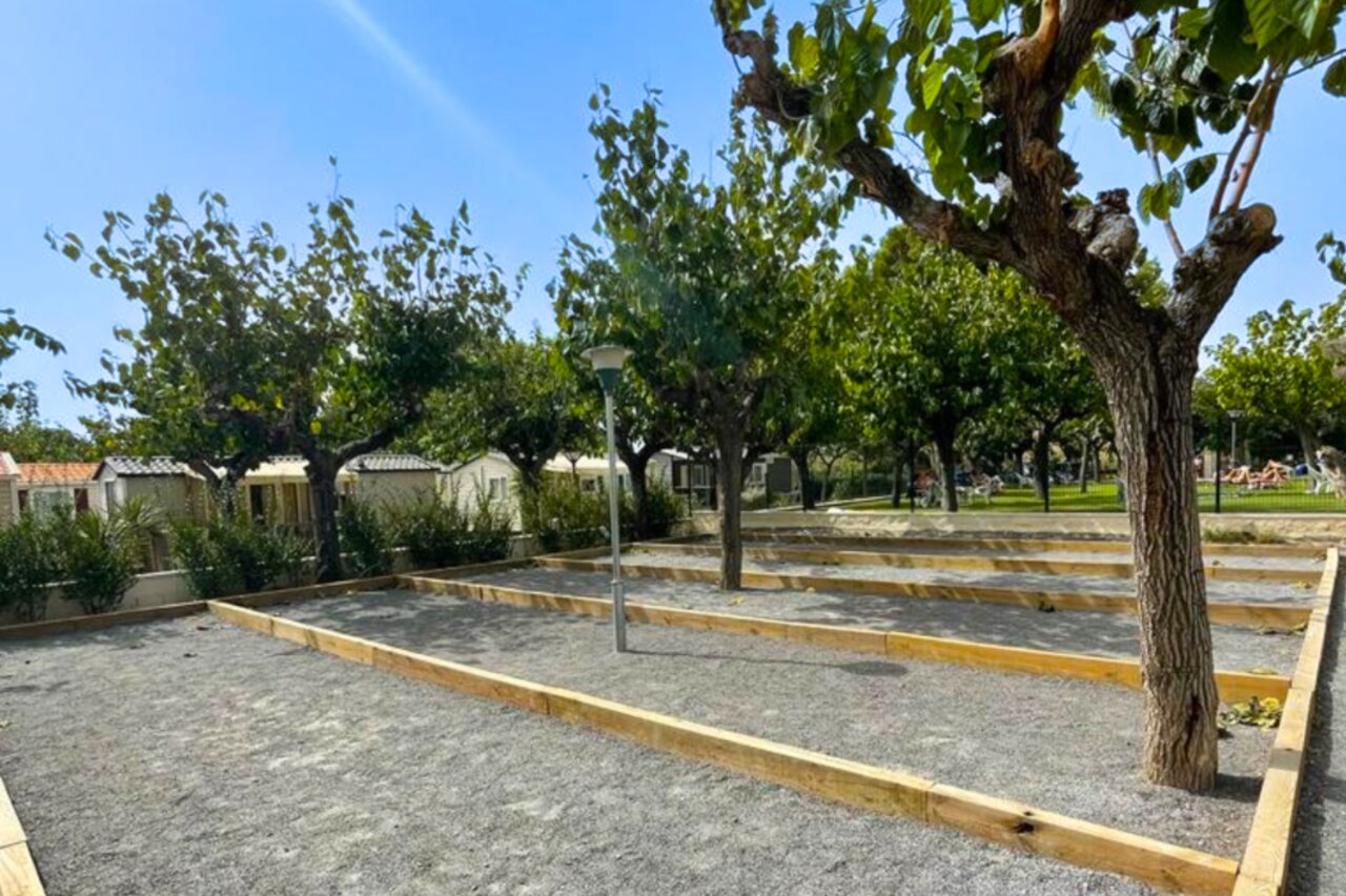 Pistas de petanca sombreadas y Mobil-homes en el camping CAPFUN Mirmanda en Cambrils - Vinyols i els Arcs.